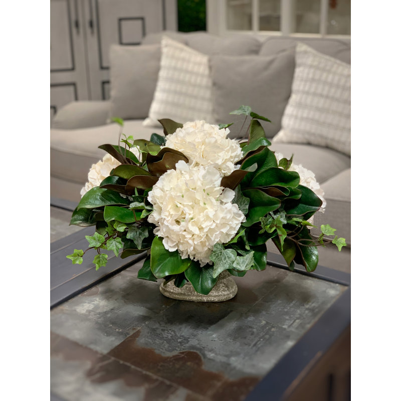 Arrangement floral d'hortensia et de feuilles de magnolia dans un vase