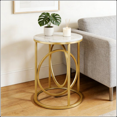 Table basse ronde avec plateau en marbre et structure en métal doré en forme de O, élégante et élégante pour un décor moderne.