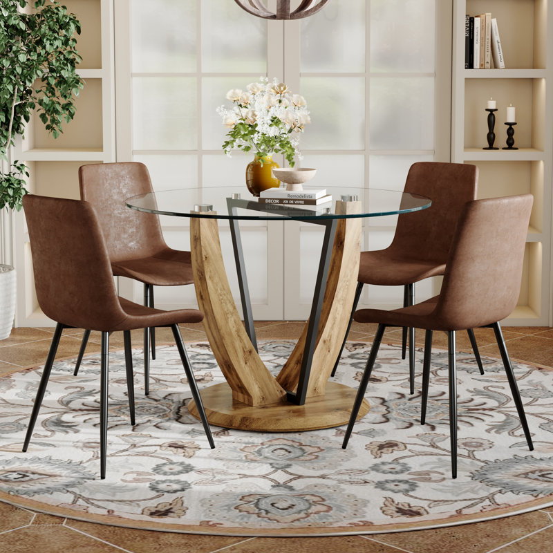 de salle à manger ronde en verre trempé transparent de 3 pouces avec pieds en MDF en forme de V, jumelée à 4 chaises en tissu brun avec un design de coussin incurvé