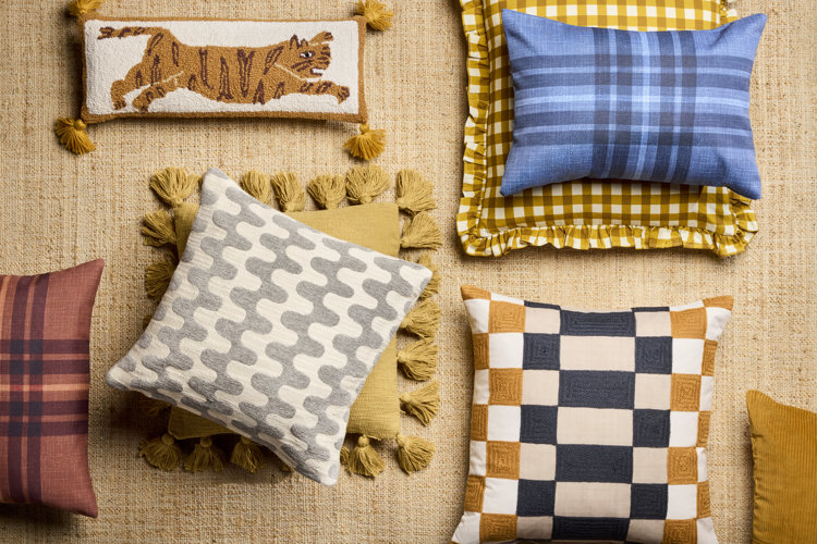 flat lay with different patterned throw pillows on top of a jute area rug
