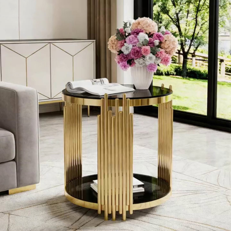 Table basse moderne en verre transparent avec structure asymétrique en métal, finition dorée et tablette inférieure pour un rangement élégant