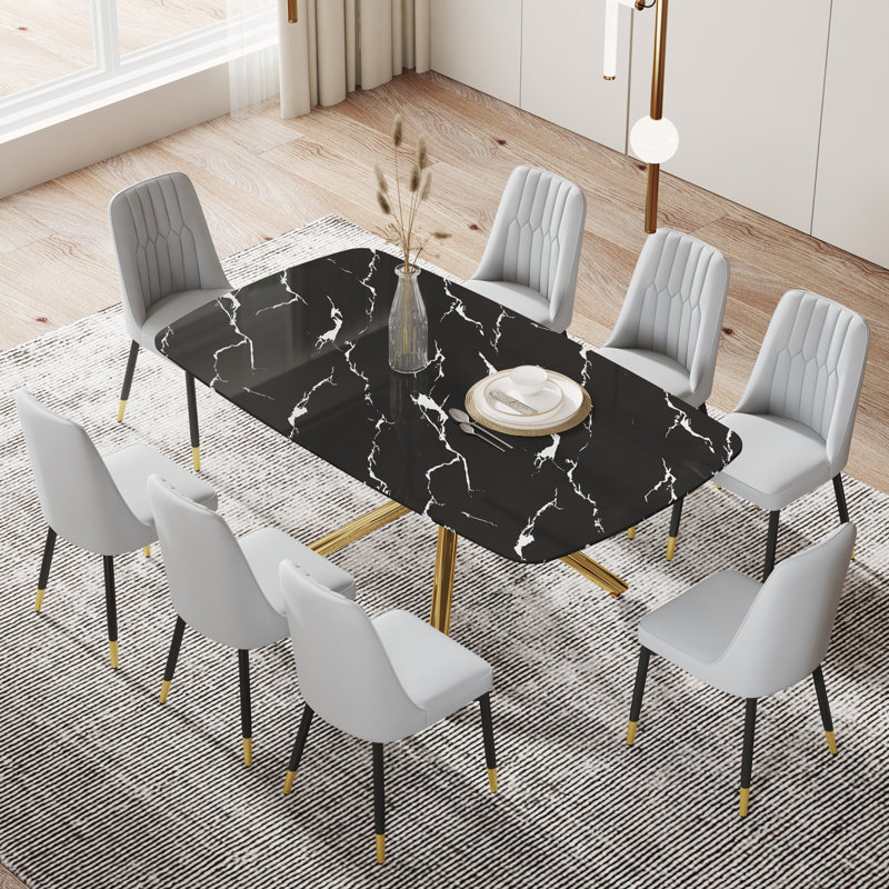 Ensemble de table et de chaises. Grande table de salle à manger rectangulaire minimaliste moderne avec plateau en verre noir imitation marbre 0,39 et pieds en métal doré, jumelée à 8 chaises gris clair avec coussins en polyuréthane.