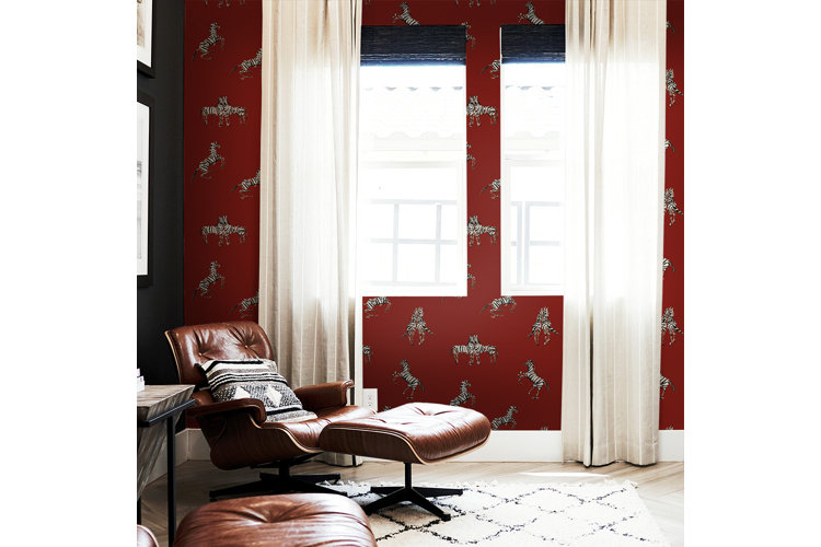 Red living room colors with red and zebra patterned wallpaper and brown leather chairs.