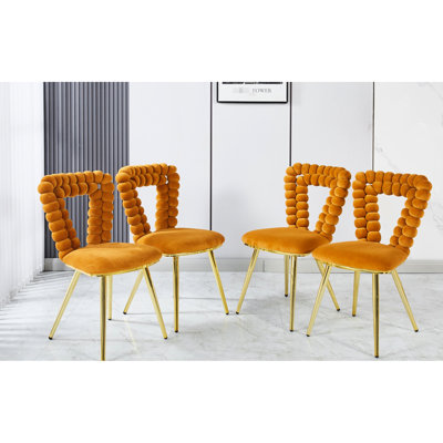 4 chaises oranges et dorées: coussins moelleux, pieds tubulaires en fer rouille, élégantes pour différentes pièces 4 chaises modernes: conception confortable, revêtement en tissu, bureau avec pieds robustes