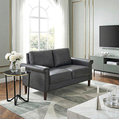 1pièce causeuse gris foncé en similicuir rembourré avec siège clouté et garniture cloutée