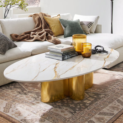 Table basse ovale minimaliste contemporaine, plateau aspect marbre veiné et piètement doré poli.