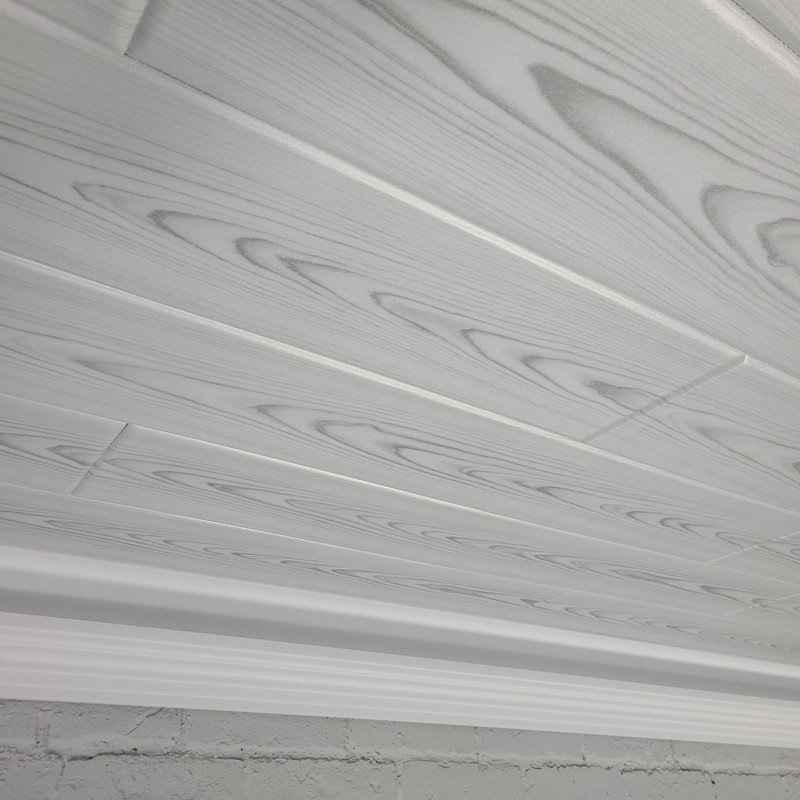 Planches de plafond légères en polystyrène expansé avec une finition imitation bois de frêne flotté. Installation facile par collage sur des plafonds texturés ou lisses pour une rénovation propre de style lambris. (86 pi²)