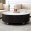 Table basse ronde en pierre frittée et MDF, plateau en faux marbre monobloc, piètement en placage noir, 2 tiroirs et pieds en acier.