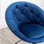 Fauteuil pivotant d'appoint en velours bleu, avec dossier capitonné.
