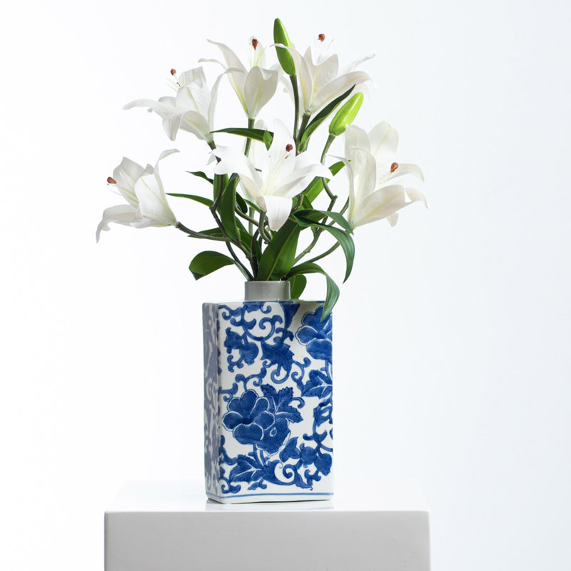 Arrangement floral de lys blancs de tous les jours dans un vase floral chinois et blanc