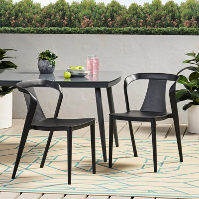 Chaise d'extérieur résistante aux intempéries, en polypropylène noir, profondeur 50,8 cm, largeur 55,5 cm, hauteur 75,5 cm, poids 4,5 kg, forme incurvée, idéale pour le jardin ou les repas en extérieur.