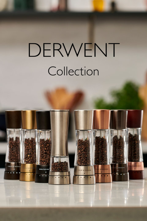 Derwent Collection of Cole and Mason pepper mills in various metallic and matte finishes lined up on a kitchen counter.