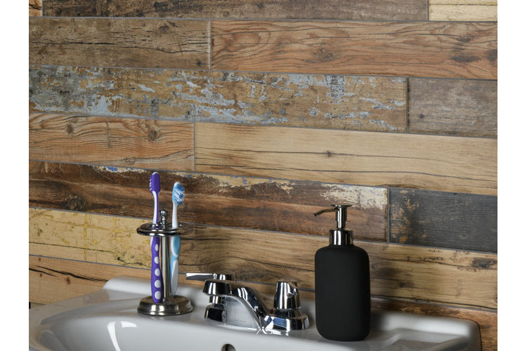 brown wood-look tiles in a bathroom behind a sink. toothbrush holder and black soap dispenser