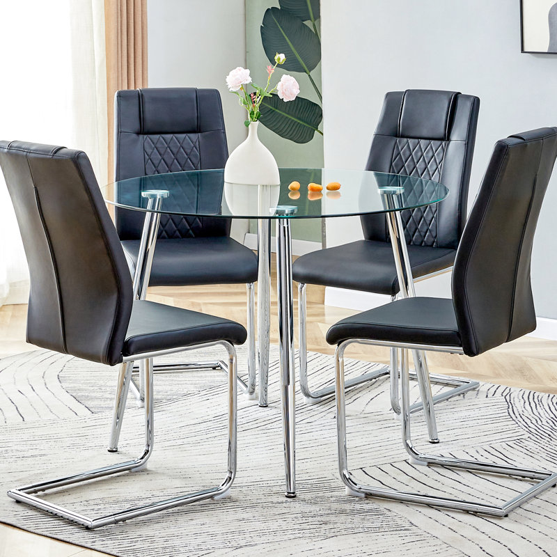 Table de salle à manger ronde pour 4 personnes avec pieds en verre transparent et en métal argenté, chaises noires en polyuréthane de haute qualité, pieds antidérapants et pattes arquées