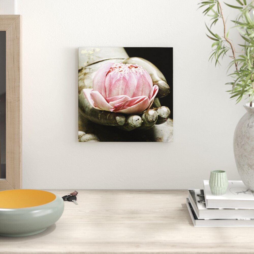 Leinwandbild Lotus auf der Hand eines Buddhas