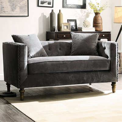 Velours gris avec coussins inclus, détails des boutons sur le dos et les accoudoirs, garniture cloutée, rembourrage en mousse de plumes pour abri haut, assise de 23 po de profondeur, profondeur de produit de 34 po, bois tourné