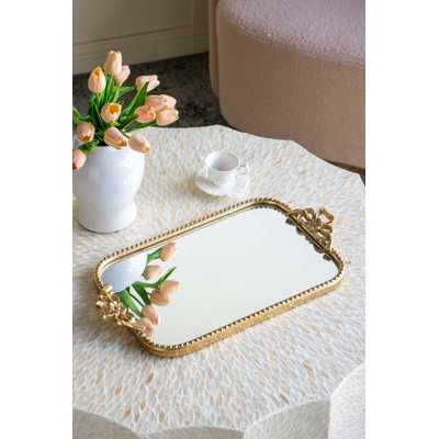 Plateau de service orné en fer doré avec surface réfléchissante réfléchissante, décoration élégante et fonctionnelle.
