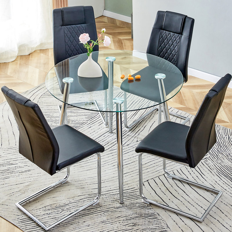 Table de salle à manger ronde pour 4 personnes avec pieds en verre transparent et en métal argenté, chaises noires en polyuréthane de haute qualité, pieds antidérapants et pattes arquées