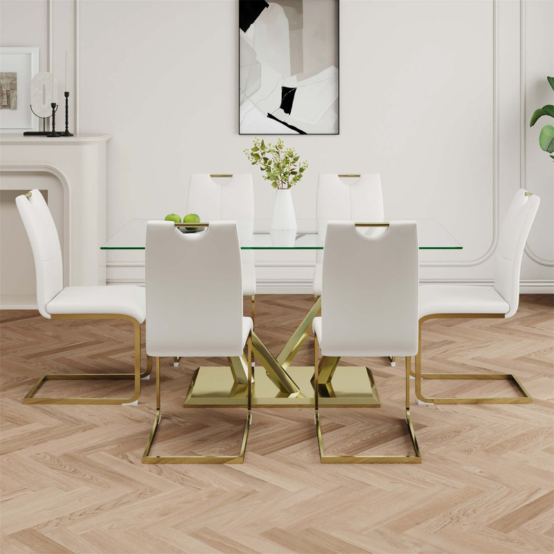 Table de salle à manger moderne en verre avec design transparent et base en acier inoxydable, ensemble de chaises blanches avec pieds plaqués or