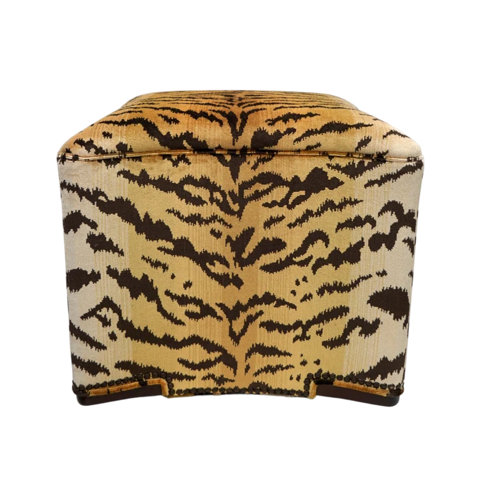 Square ottoman upholstered in a brown and tan tiger stripe fabric with nailhead trim detail.