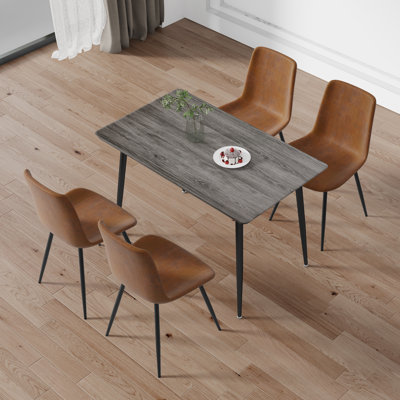 Ensemble de table de salle à manger de style industriel, table en bois aggloméré gris avec pieds en fer noir et 4 chaises en tissu brun avec coussins courbés