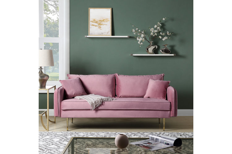 soft pink couch next to dark olive walls