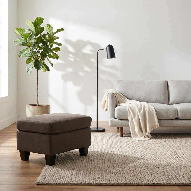 Repose-pieds rembourré avec pieds tournés en bois et design minimaliste contemporain