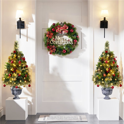 Arbres de Noël pré-éclairés avec baies rouges et pommes de pin