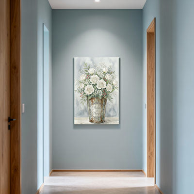 Plantes et fleurs roses blanches dans un seau rustique avec verdure