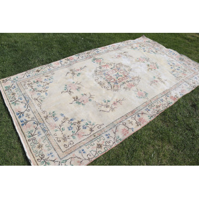 Grand tapis turc rétro avec motif floral dans des tons doux parfait pour rehausser le décor du salon