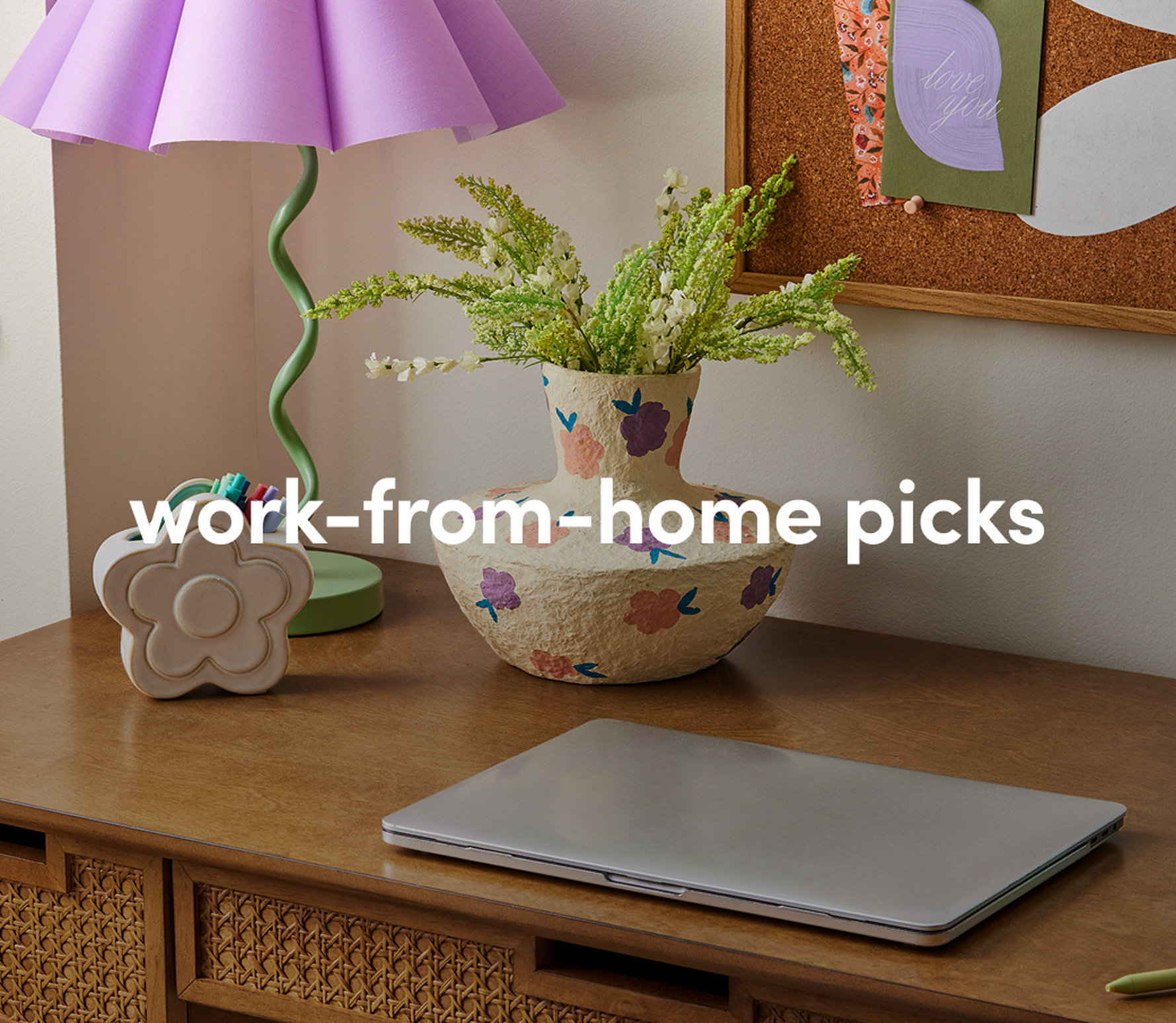 A modern home office setup with a desk, lamp, and potted plant near a window.