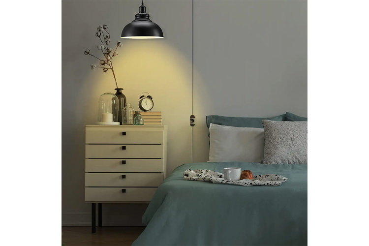 metal swag light hanging over a bed