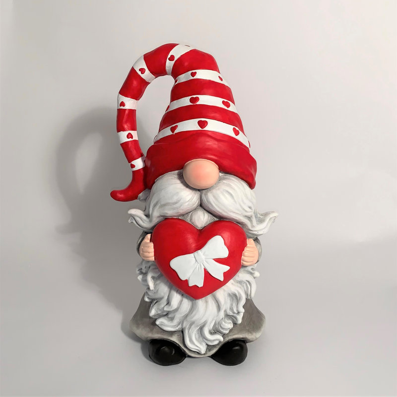 Gnome de jardin en magnésium tenant un cœur avec un nœud et un chapeau rayé rouge "The Valentinos"