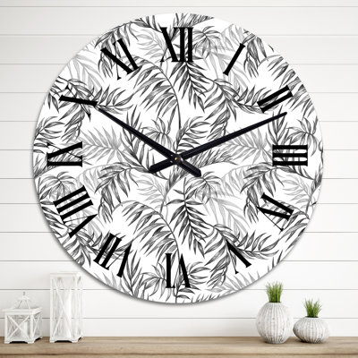 Horloge murale à motif de feuilles de palmier noires et blanches sur fond blanc