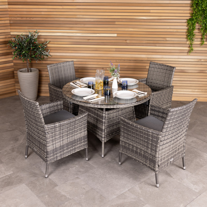 Nohemi 4 - Person Wicker Patio Dining Set with Round Table , Cushions Included, Grey