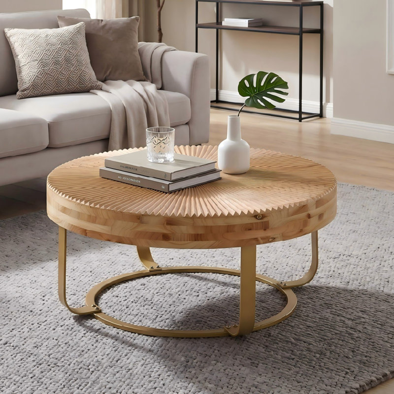 Table basse ronde en bois massif avec pieds en métal doré, finition naturelle sculptée