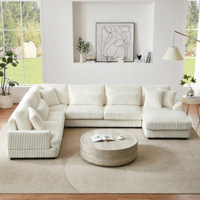 Salon spacieux en forme de U avec revêtement en velours côtelé beige et coussin amovible