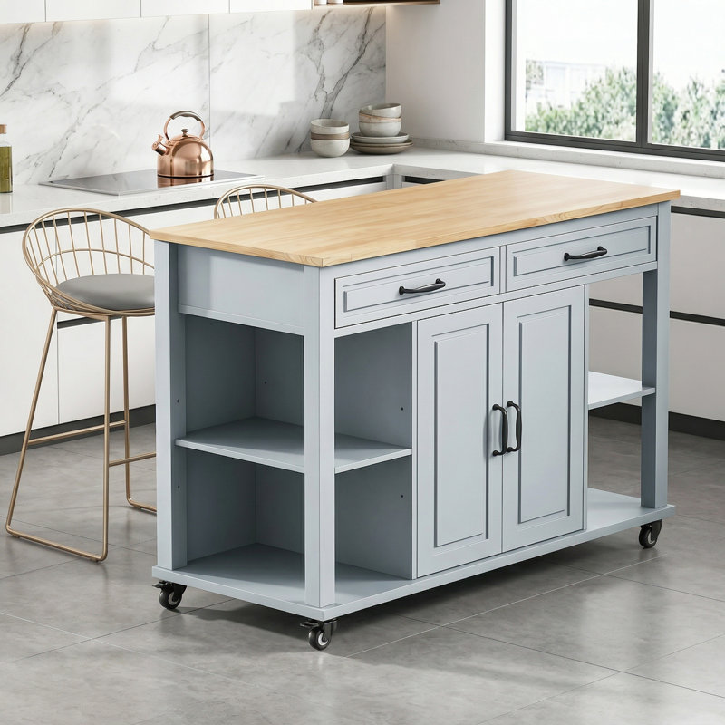 L'îlot de cuisine gris-bleu comprend une table de salle à manger rétractable en placage d'hévéa avec des tablettes de rangement, des prises de courant, deux tiroirs et deux armoires pour un maximum de commodité.