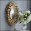Magnifique miroir mural avec motif soleil levant et finition dorée, parfait pour rehausser tout espace.