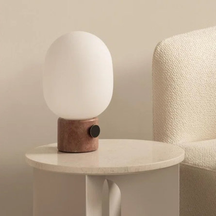 Table lamp on a side table next to a chair.