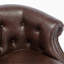Chaise en similicuir brun classique, dossier à boutons, fauteuil élégant, finition décorative, capitonnage, dossier confortable, structure en bois franc