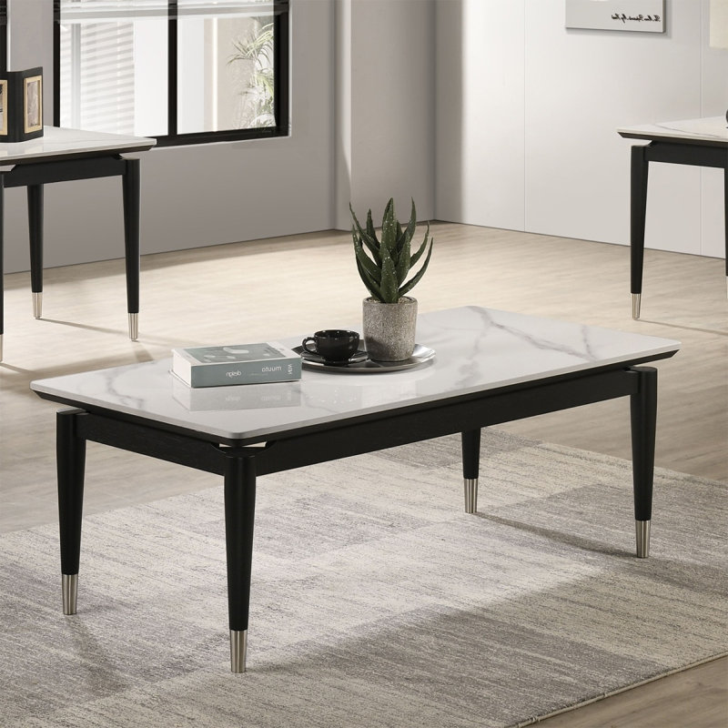 Table basse de style contemporain avec plateau en pierre frittée et pieds en flèches argentées avec finition noire et blanche