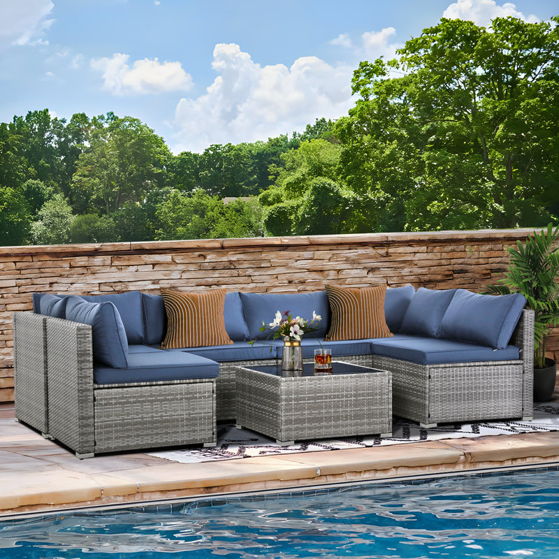 Ensemble de conversation modulaire de 7 pièces en résine tressée résistant aux intempéries pour patio, avec coussins et table basse.