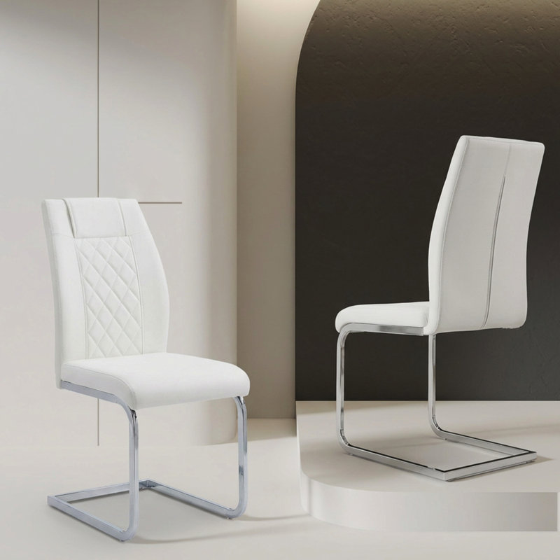 Ensemble de 4 chaises de salle à manger blanches à dossier haut en similicuir avec finitions argentées. Robustes et stables, elles peuvent accueillir confortablement plusieurs personnes et s'adaptent à différentes pièces.