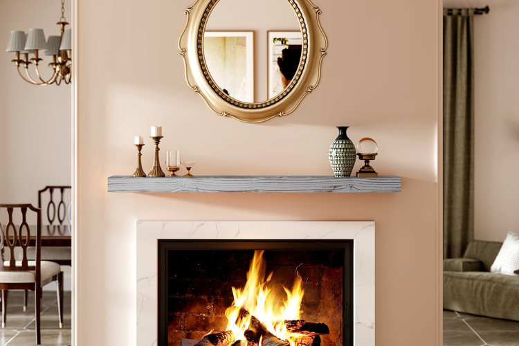 traditional living room with marble fireplace surround, gray wood mantel shelf decorated with candles and vases, and gold-framed mirror