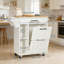 Îlot de cuisine avec rangement pour poubelle et prise de courant, chariot de cuisine mobile à roulettes avec armoire basculante cachée, support à épices et roues verrouillables pour un rangement et une mobilité accrus
