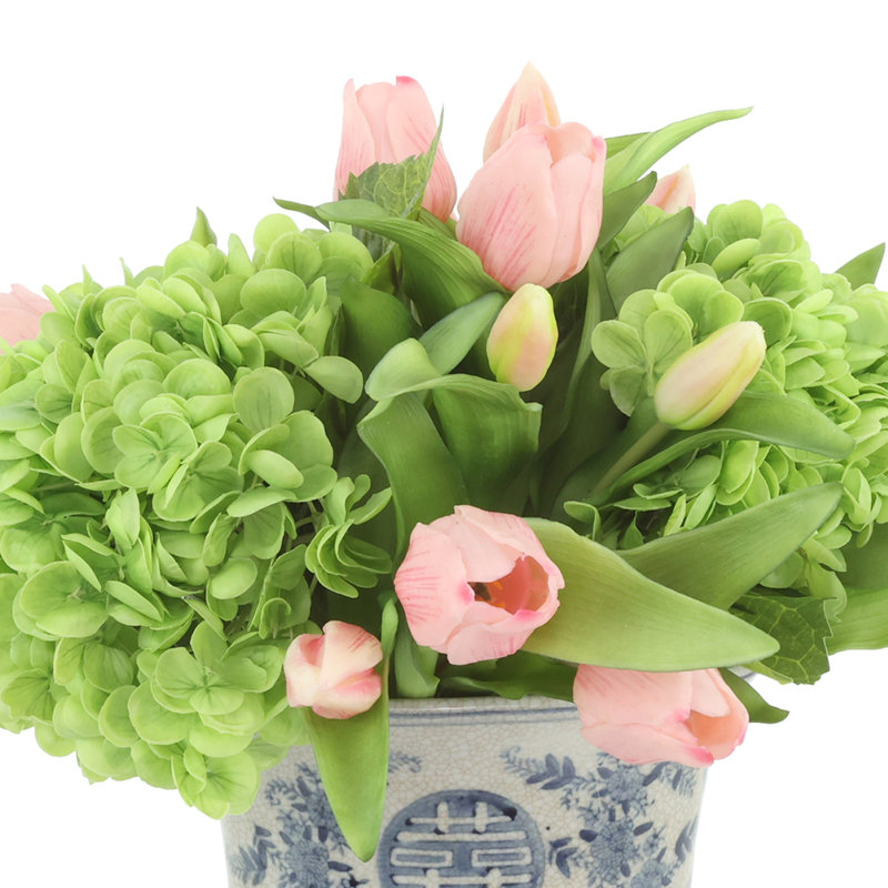 Véritable hydrangées et tulipes disposées dans un vase en céramique
