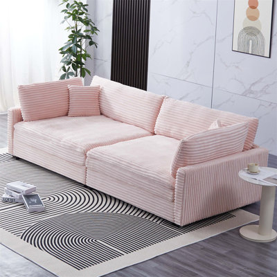 Canapé spacieux en velours côtelé avec plusieurs dossiers et coussins décoratifs, parfait pour créer un espace de détente confortable et invitant