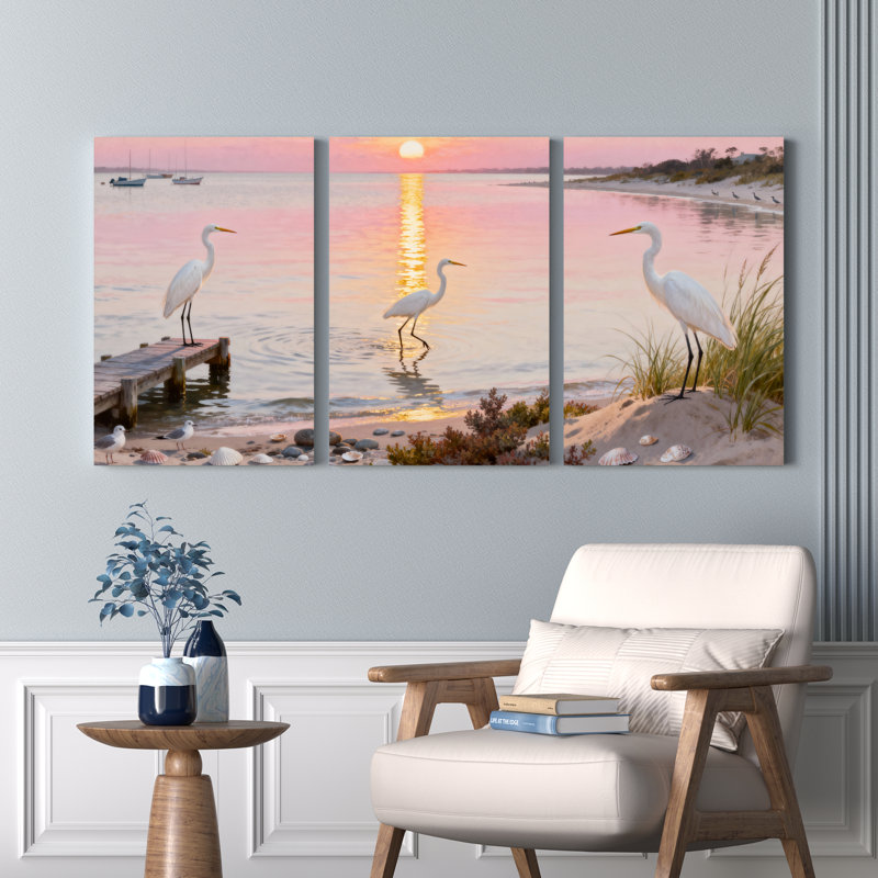Ensemble de 3 toiles murales montées sur châssis représentant un coucher de soleil sur une plage avec un héron