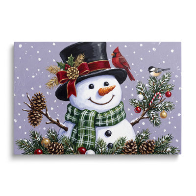 Tableau multicolore sur toile représentant un paysage, un bonhomme de neige et des pommes de pin, idéal pour décorer un salon, une salle à manger ou une chambre.